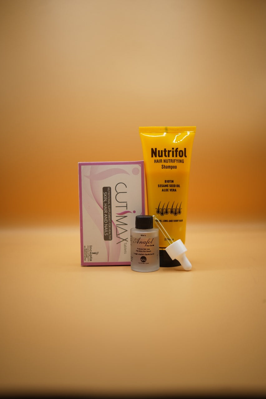 Collection of hair care products including a yellow bottle, pink box, and small bottles on a beige background